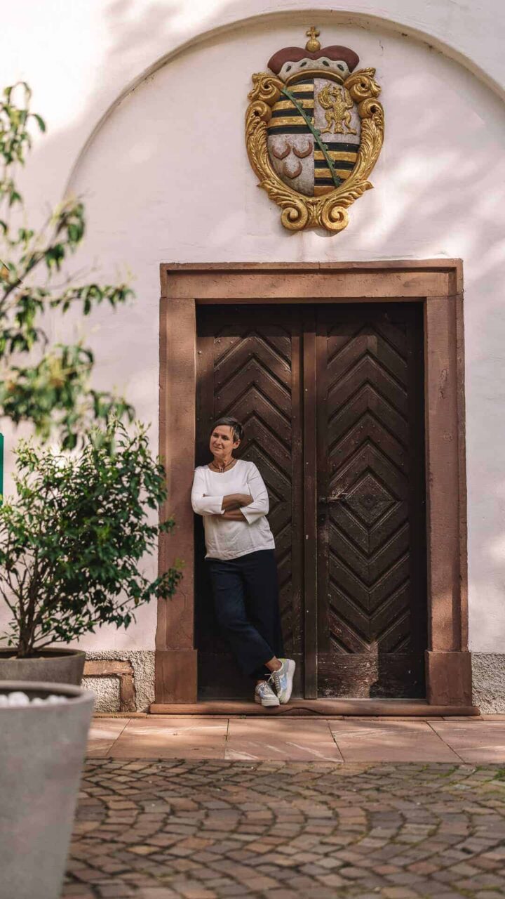 Eine Frau steht vor einer Tür, die mit dem Wappen von MCS-Immobilien geschmückt ist.
